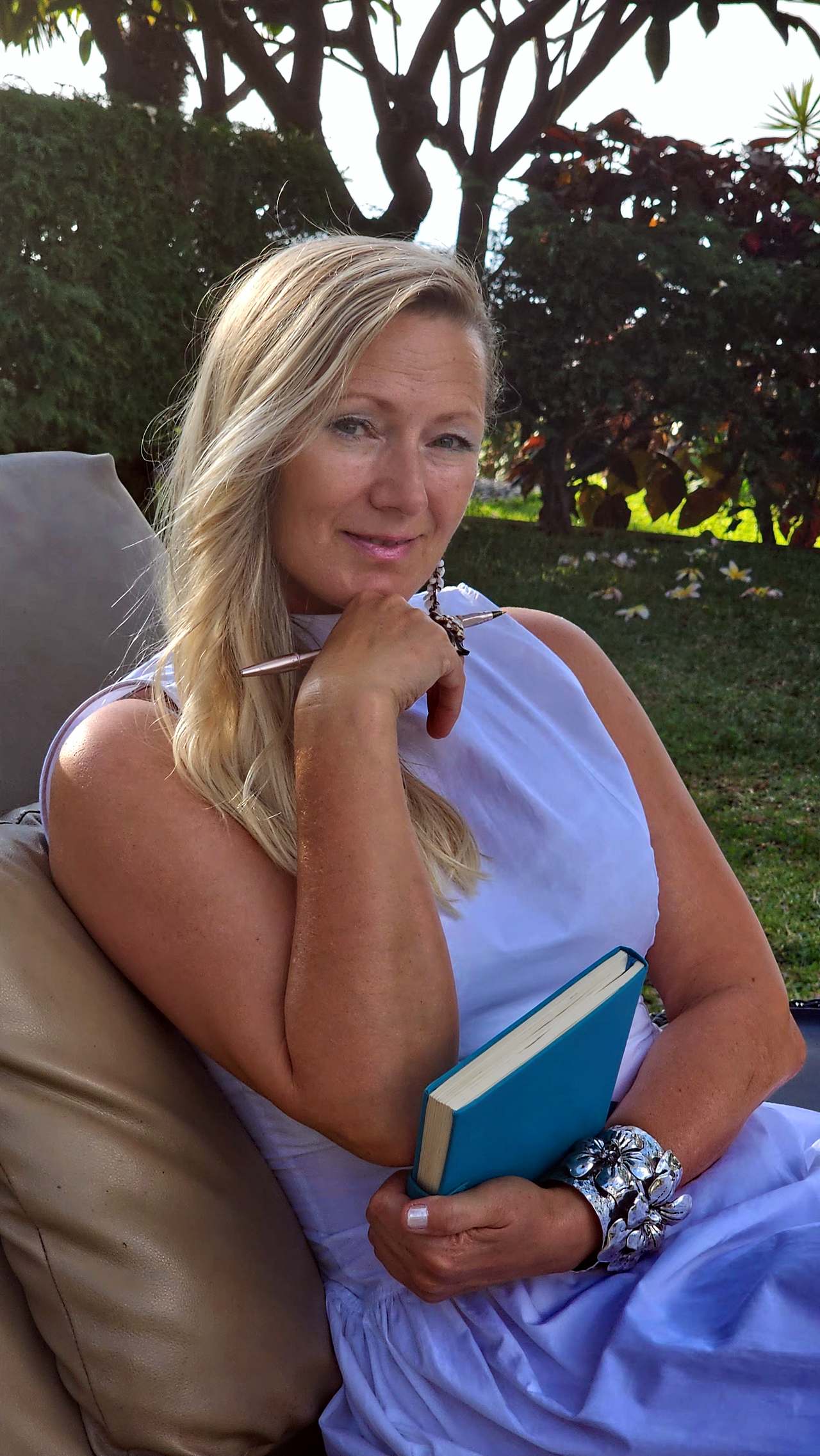 Mellanie Tara seated outdoors with her journal